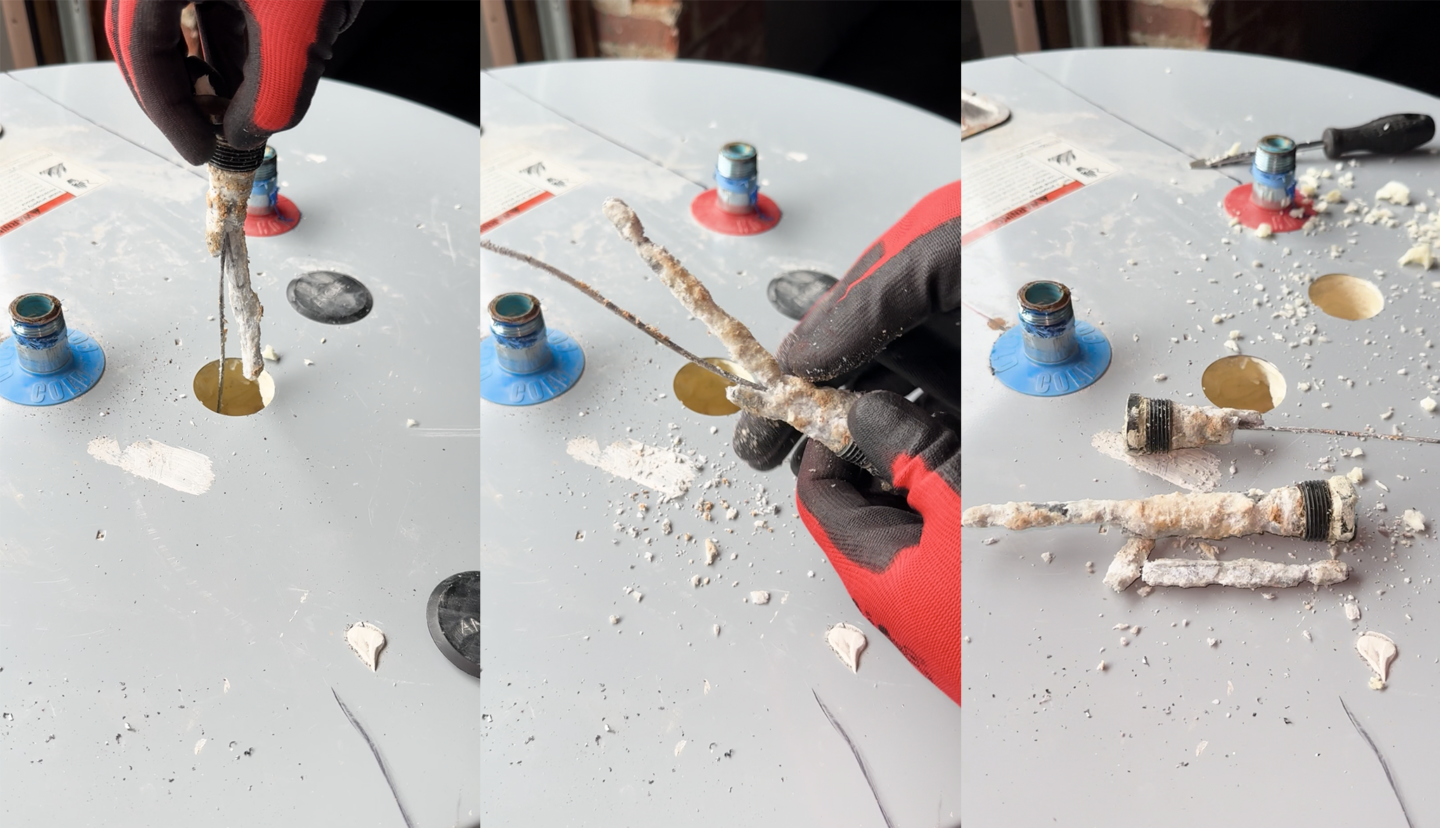 Degraded anode rod covered in corrosion residue being removed from the top of a water heater.